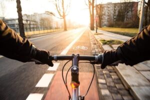 Cyklist pendlar på en markerad cykelbana i morgonljus