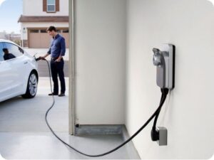 Elbil laddas med kabel från en väggmonterad laddbox i garage