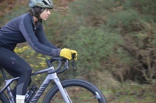 Cyklist i framåtlutad position med händerna på bockstyret